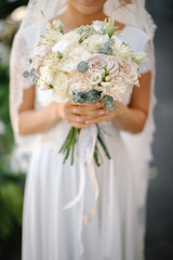 Bride with a beautiful wedding bouquet in light colors