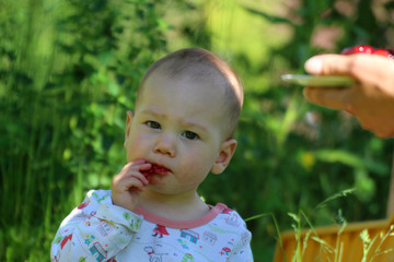 Baby isst Himbeeren mit verschmiertem Mund