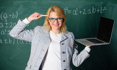 Idea on her mind. Digital technologies concept. Woman teacher wear eyeglasses holds laptop surfing internet. Educator smart clever lady with modern laptop surfing internet chalkboard background