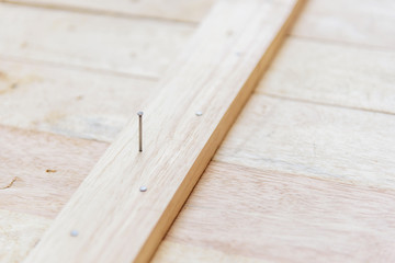 Worker hammer the nail into the wood