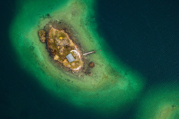 Kleine Insel mit Hütte in der Mitte eines Sees - Luftaufnahme