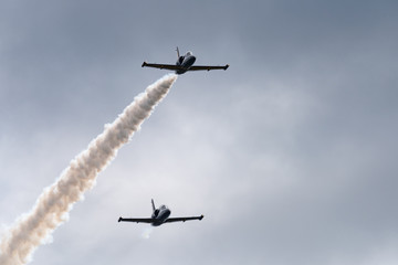Low angle view of airshow in cloudy sky