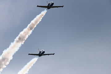 Low angle view of airshow in cloudy sky