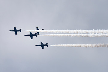 Low angle view of airshow in cloudy sky