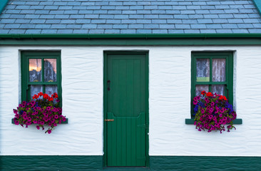 Fototapeta na wymiar colouful flower boxes on windows of old vintage irish cottage