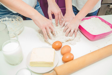 Hands Of Mother And Daughter Knead Dough For Pizza