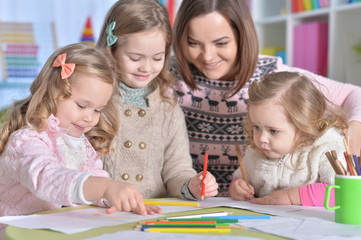 Portrait of a cute mother and girls drawing