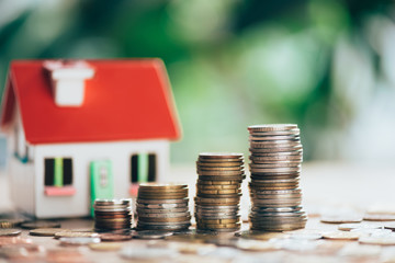 close-up view of stacked coins and house model, savings concept