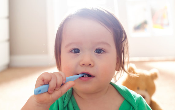 Toddler boy brushing his teeth with a toothbrush