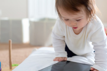 Naklejka premium Toddler boy with a tablet computer device