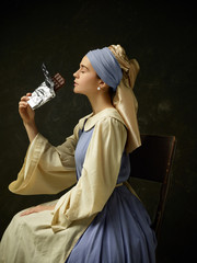 Medieval woman in historical costume wearing corset dress and bonnet. Beautiful peasant girl...