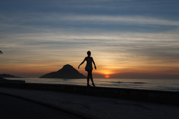 menina dan&ccedil;a no nascer do sol na praia do recreio dos bandeirantes, rio de janeiro