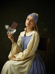 Medieval woman in historical costume wearing corset dress and bonnet. Beautiful peasant girl...