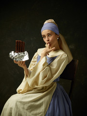 Medieval woman in historical costume wearing corset dress and bonnet. Beautiful peasant girl...