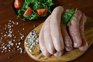 rohe Bratwürstchen auf Holzbrett