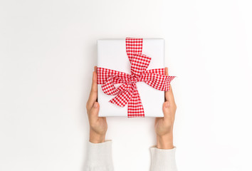 Person holding a Christmas gift box on a white background