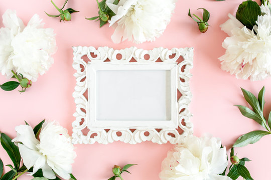 Carved, white frame decorated of white peony flowers on pink background. Peony texture. Flat lay, top view. 
