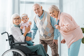 Obraz premium happy senior people with toddler in nursing home