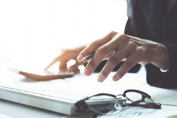 Business accounting, Business man using calculator with computer, budget and loan paper in office.