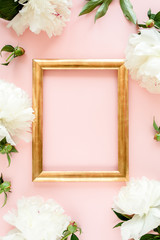 Obraz na płótnie Canvas Gold frame decorated of white peony flowers on pink background. Peony texture. Flat lay, top view. 
