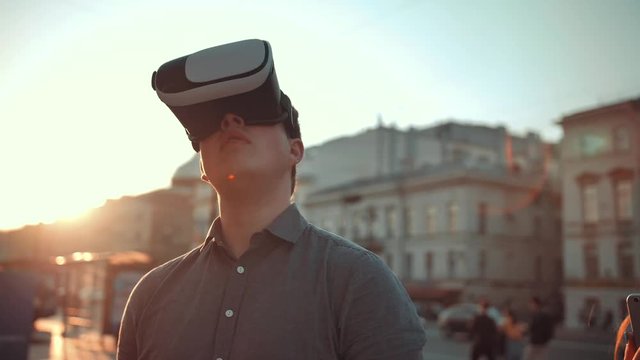Attractive Guy and handsome girl in vr glasses in city crowded street trying to find something interesting additional information of this place with smartphone. Virtual reality concept.