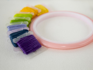 accessories for embroidery. white canvas. copy space. scissors, floss, hoops.