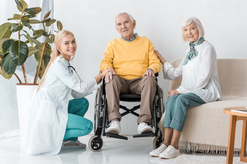 Obraz premium young female doctor sitting with senior patients in clinic