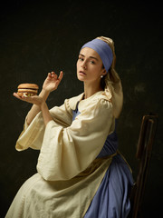 Medieval Woman in Historical Costume Wearing Corset Dress and Bonnet with burger. Beautiful peasant...
