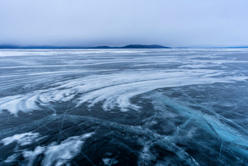 Lake Khubsugul is covered with ice and snow, strong cold, thick clear blue ice. Lake Khubsugul is a frosty winter day. Amazing place