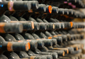 old wine bottles covered with dust and cobwebs are in the wine cellar