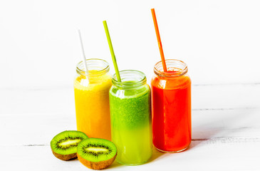 Fresh detox juices in glass bottles on white background