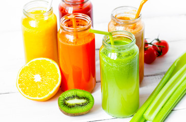 Fresh detox juices in glass bottles on white background