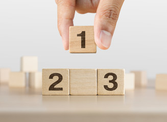 Hand arranging wooden blocks stacking as a podium on white background. Success, win, winner,...