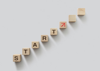 Wooden blocks arranged in stair shape with the word START. Start, Start up, new career or new business, start to success or mindset concept.