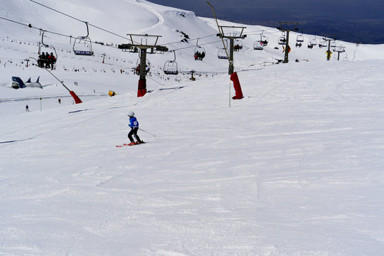 A boy in ski suit, helmet and sunglasses skiing from snowy mountains in Serra Nevada
