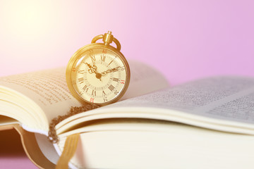 An open book with old watch, education concept
