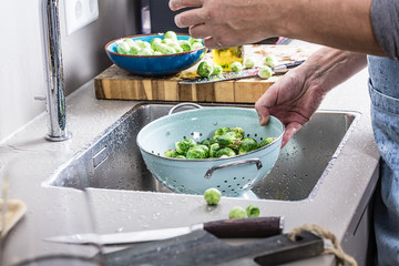 washing raw Brussels sprouts in kitchen sink