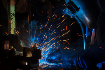 Industrial worker is welding in construction plant