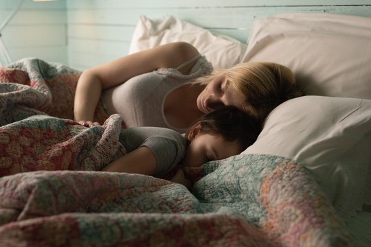 Mother and daughter sleeping in bedroom