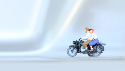 Fototapeta premium Miniature people bride and groom couple with motorcycle