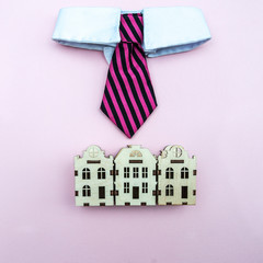 Fototapeta premium Mayor, the intelligentsia of the city concept. A tie with a white collar above the toy houses of the city, a symbol of management. View from above, flat lay