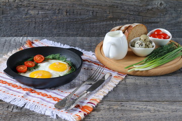 Breakfast on the table. Fried chicken eggs and fresh vegetables.