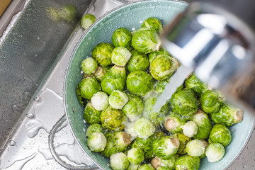 washing raw Brussels sprouts in kitchen sink