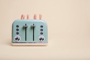 Retro green 4 slice toaster on a vintage tan background with four slices of toast popping out