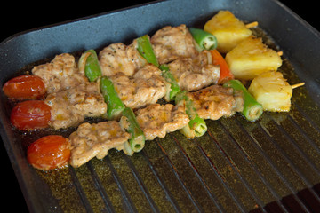 Barbecue pork grilled in the pan on black background