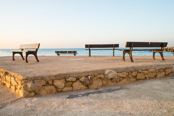 Fototapeta na wymiar Seaside benches under sunlight