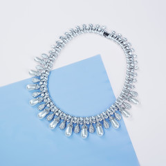 Beautiful necklace on blue paper background
