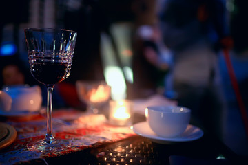 red wine glass serving / romantic dinner in the interior of the restaurant, a table served with a glass of grapes wine