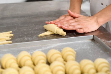 Baker is making crescent rolls © yuriygolub