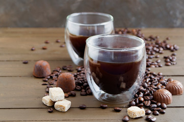 Coffee in double-walled glass on a wooden table.